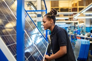 woman inspecting solar panel at factory